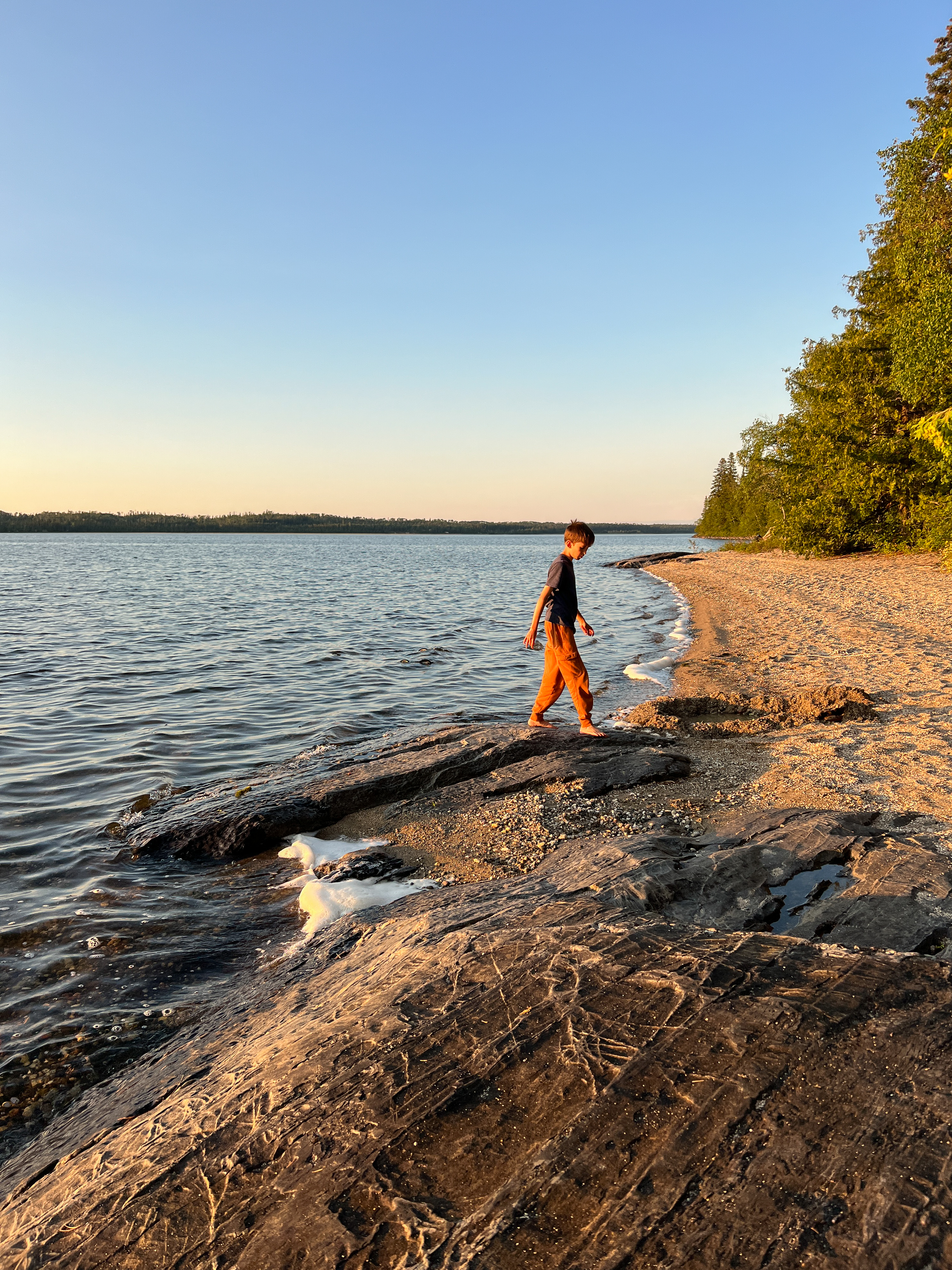 Young boy walks on beach