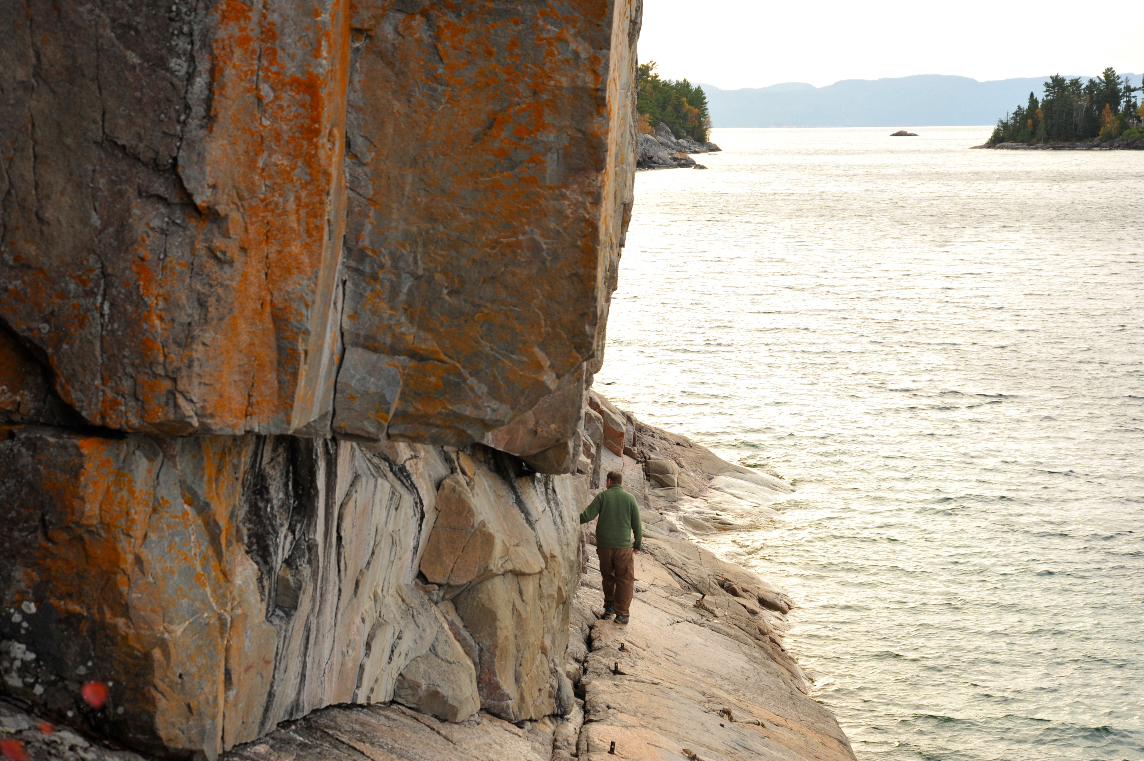 Venture carefully onto the ledge of sloping granite at the foot of the cliffs to view the pictographs. Credit: Virginia Marshall