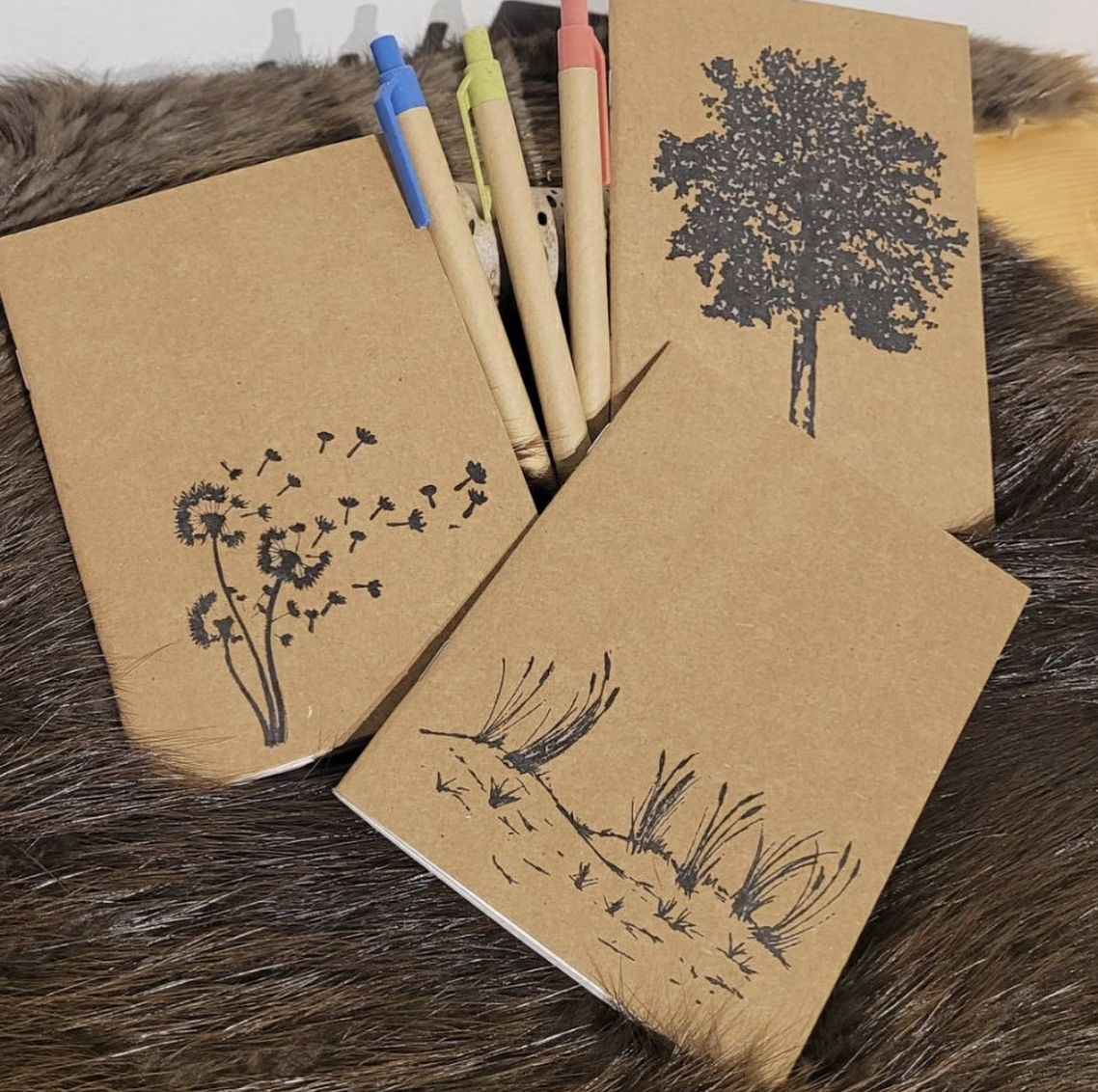 recycled paper notebooks with dandelion, tree and grass prints of the covers