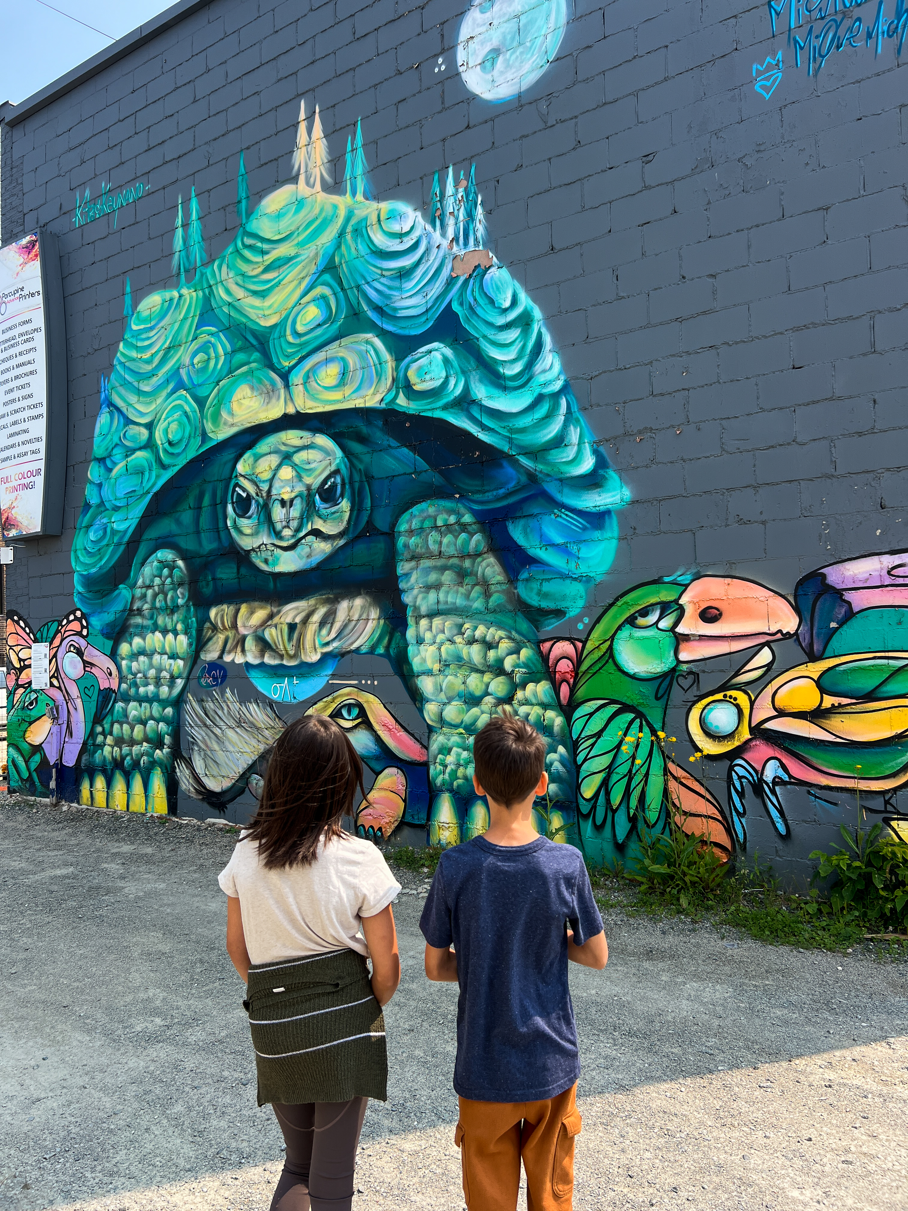 Young kids looking at an indigenous mural