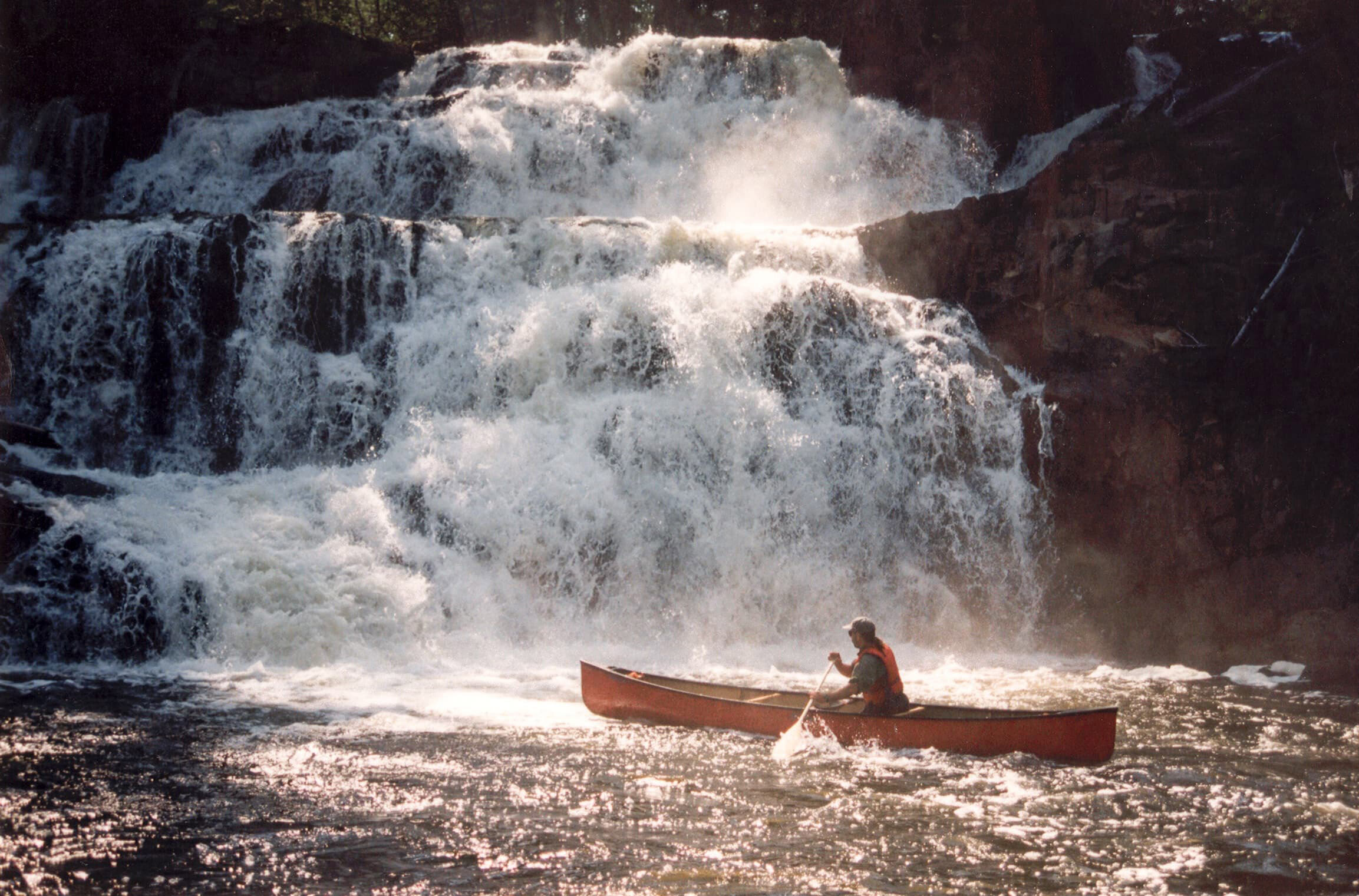 canoe close to waterfall