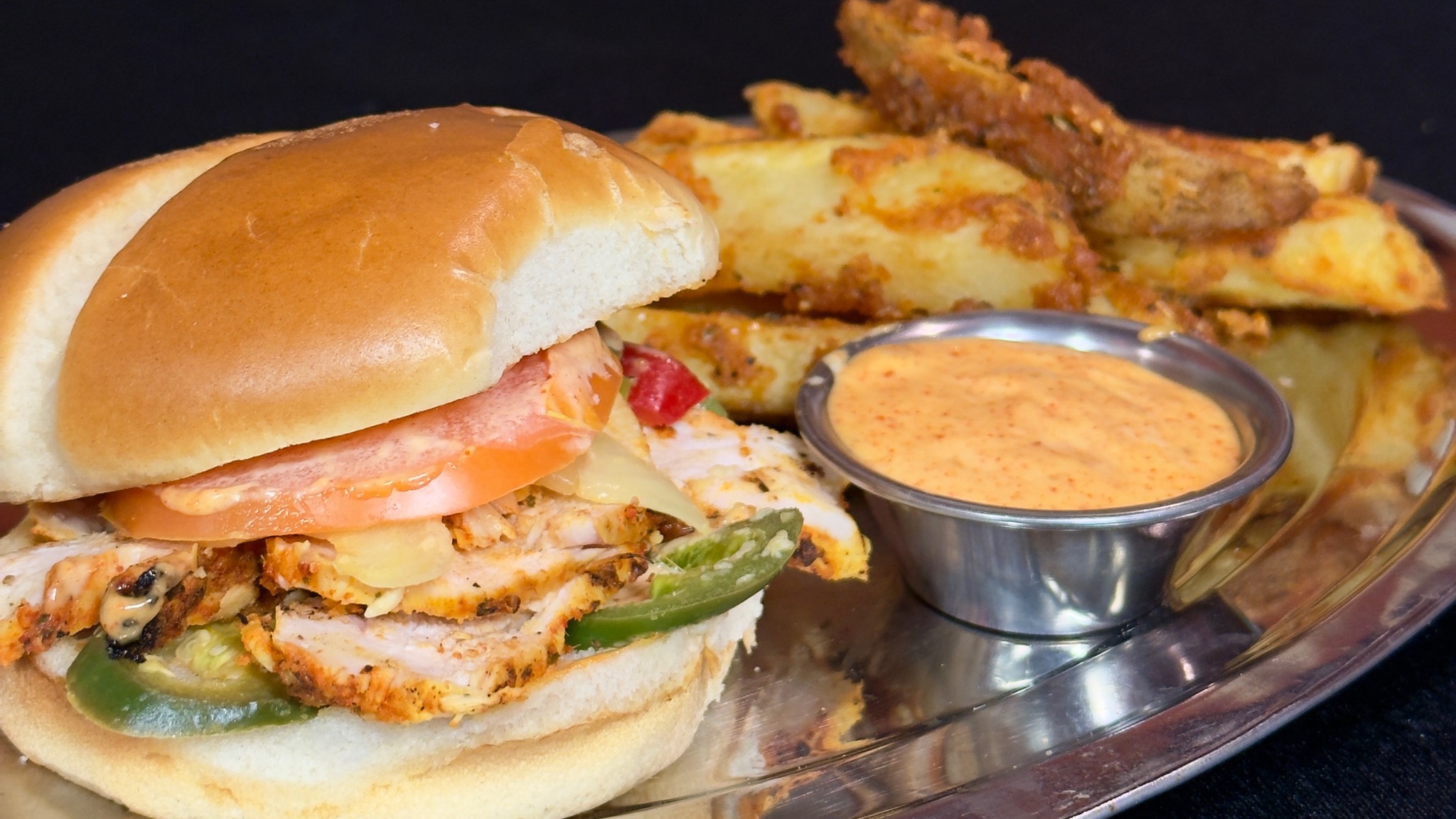 A masala chicken burger with fried potato wedges