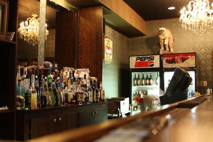 The Sovereign Room bar, eclectically decorated with crystal chandeliers, antique pop coolers and a stuffed wildcat perched atop the cooler.