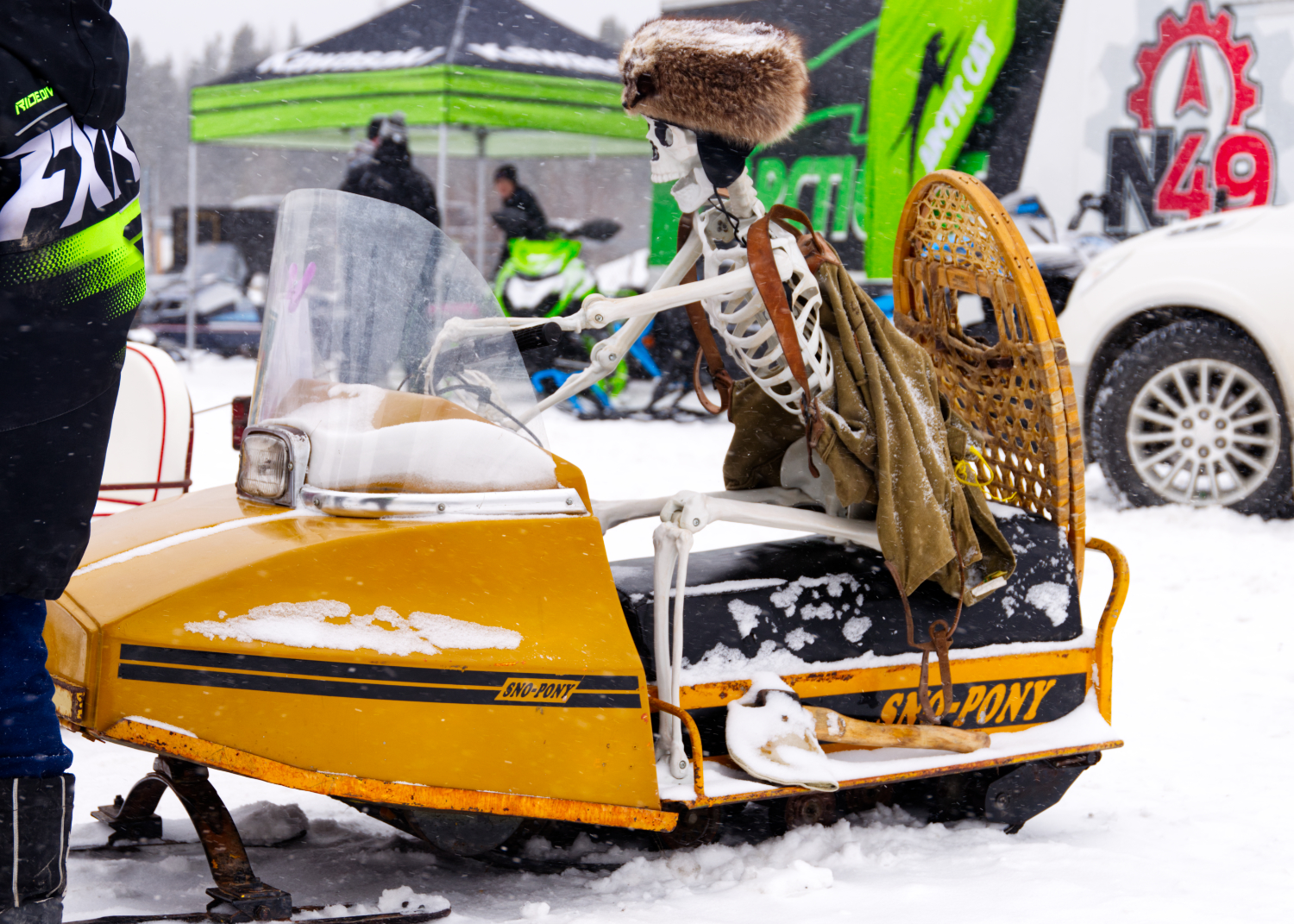 A life-sized plastic skeleton wearing a fur cap sits on a vintage 1971 Sno-Pony snowmobile at the Big Winter Festiglace.