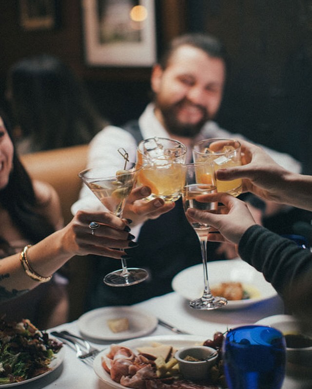 smiling people toast over top of a dining table at Giorg Cucina é Barra.