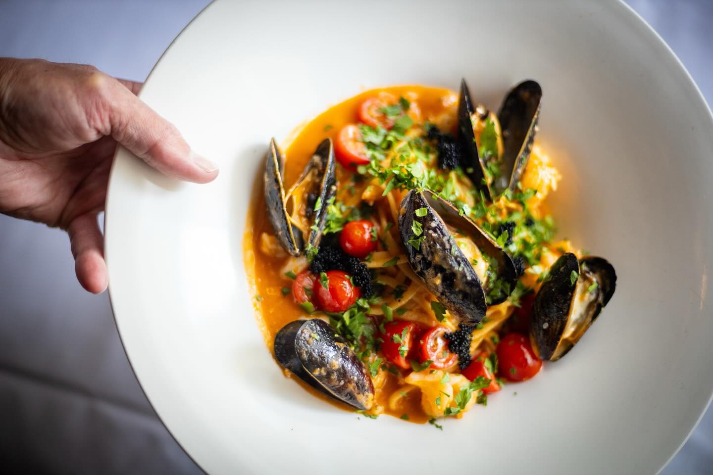 a dish of mussels in a vegetable broth