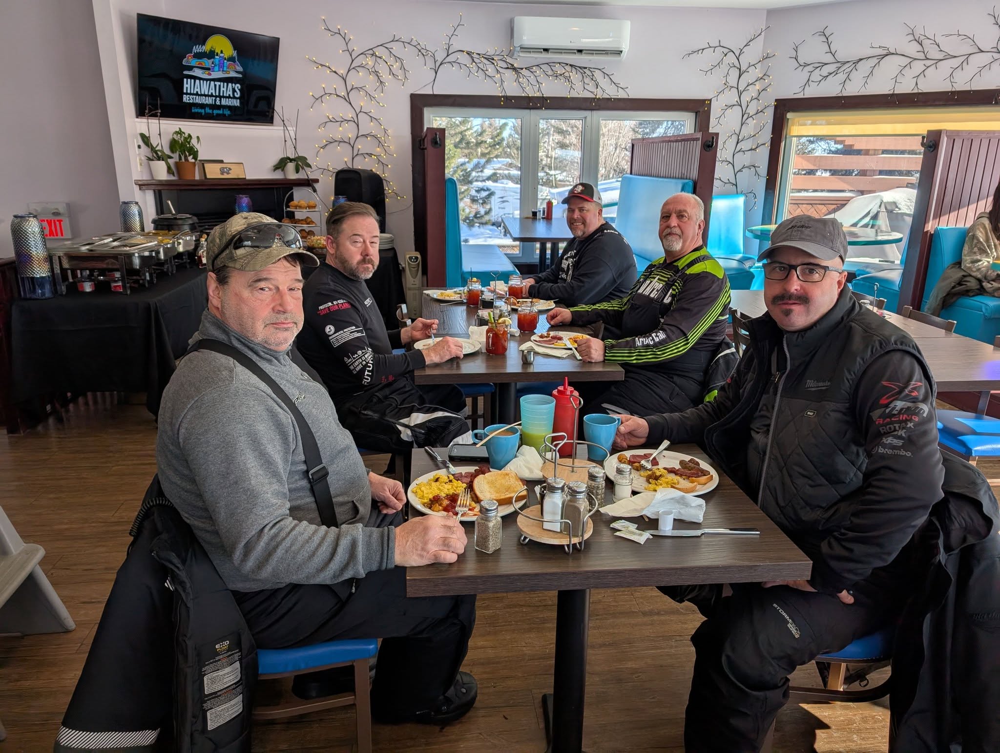 Snowobilers eating breakfast at a bar and grill.