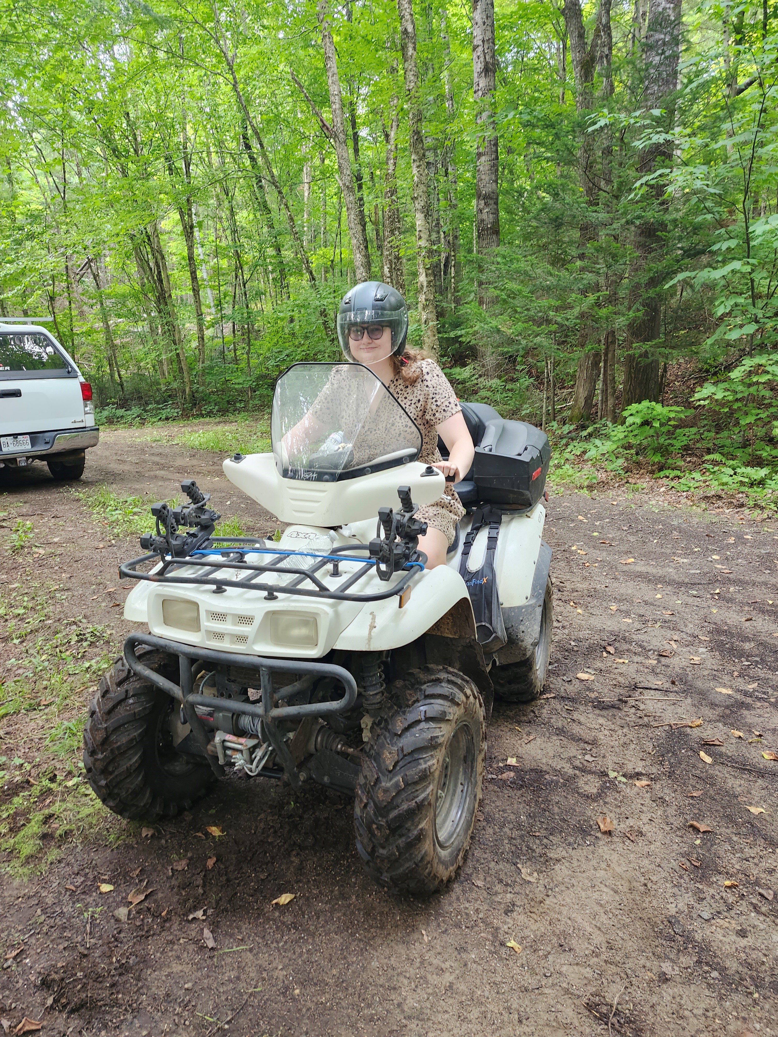 A woman on an ATV in a forest.