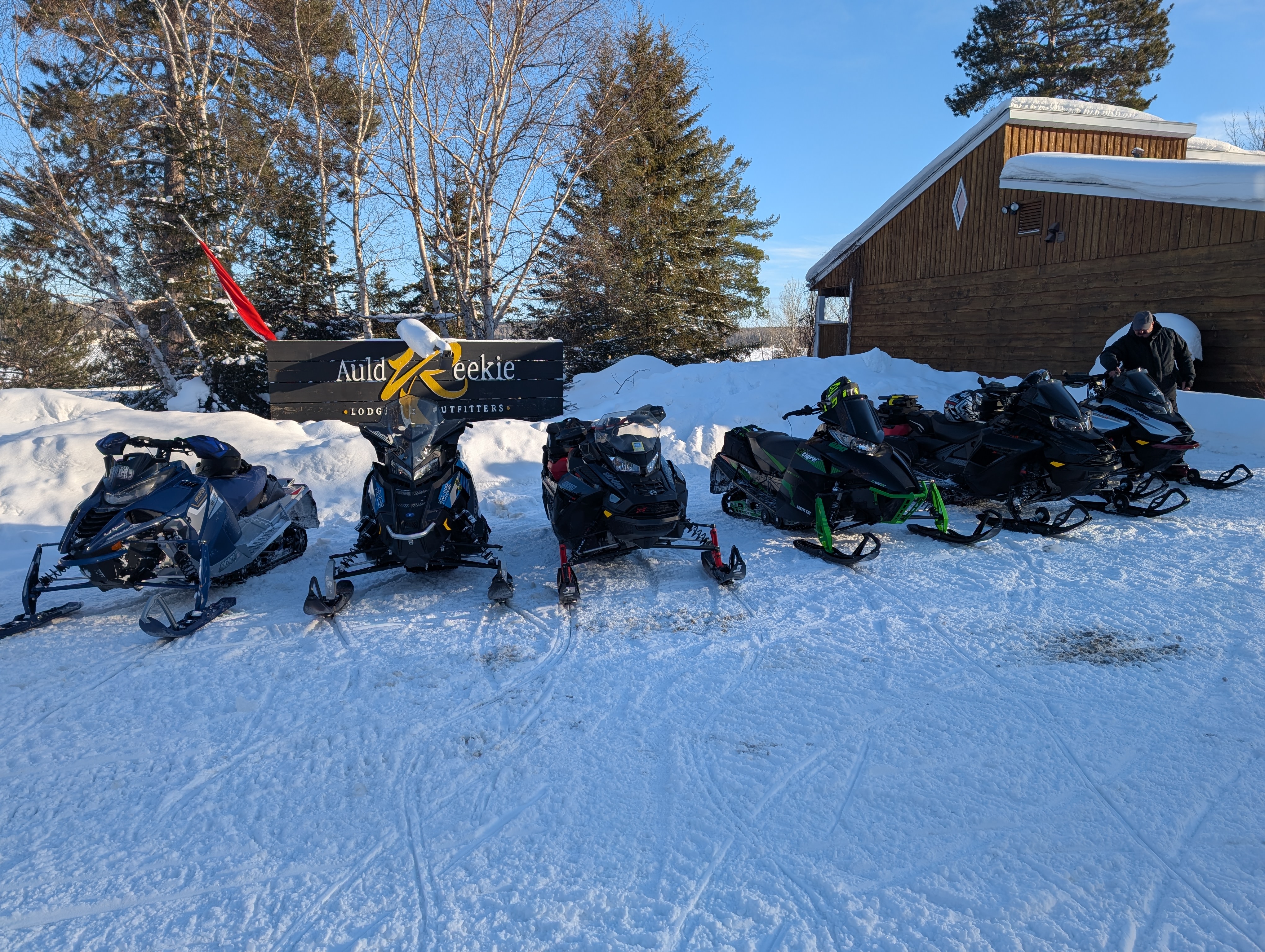 A line of snowmobiles outside a lodge called Auld Reekie in Ontario.