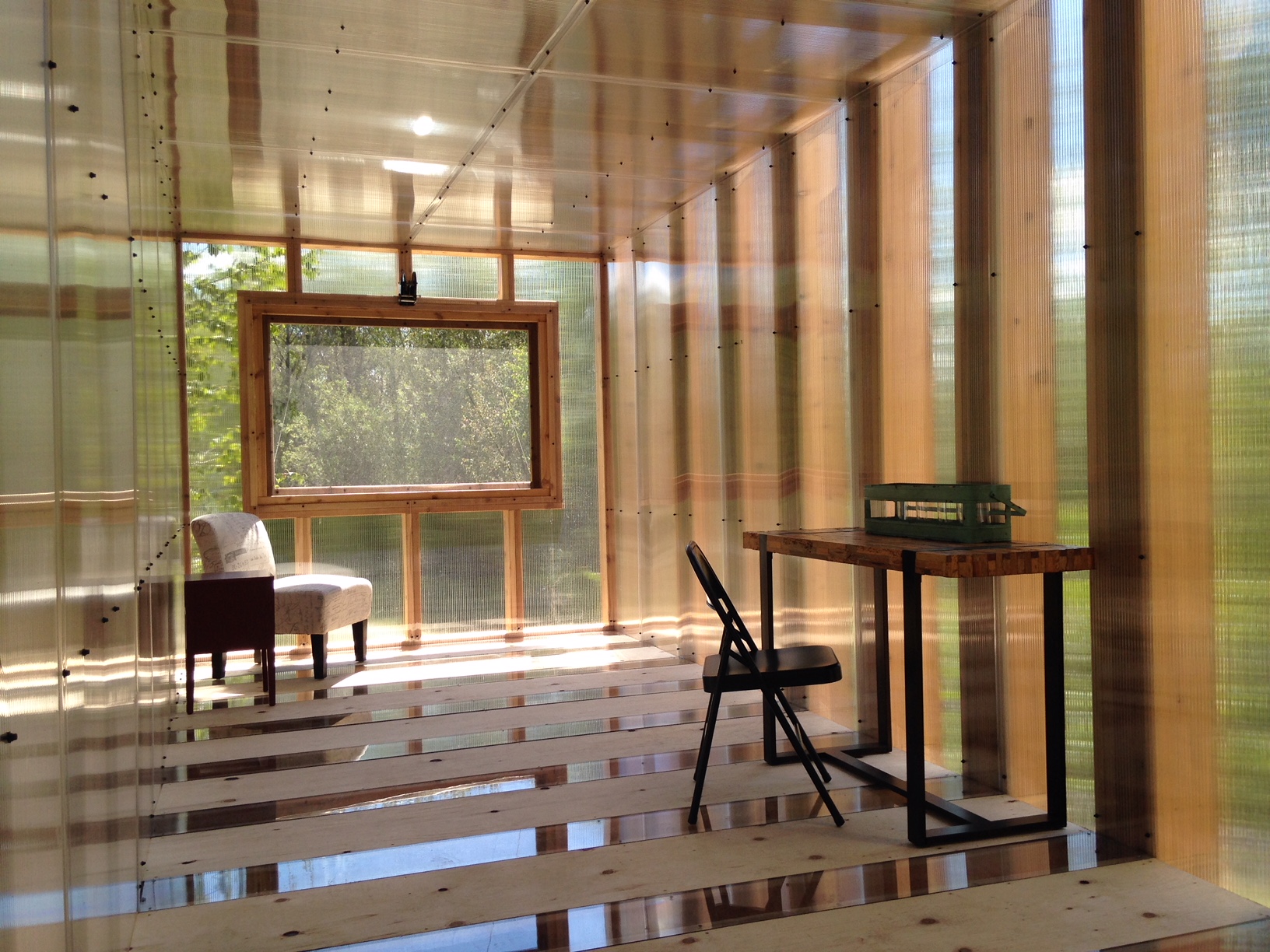 a sunny artist's studio with wooden floors, beams and glass walls in the forest at Sioux Narrows-Nestor Falls.