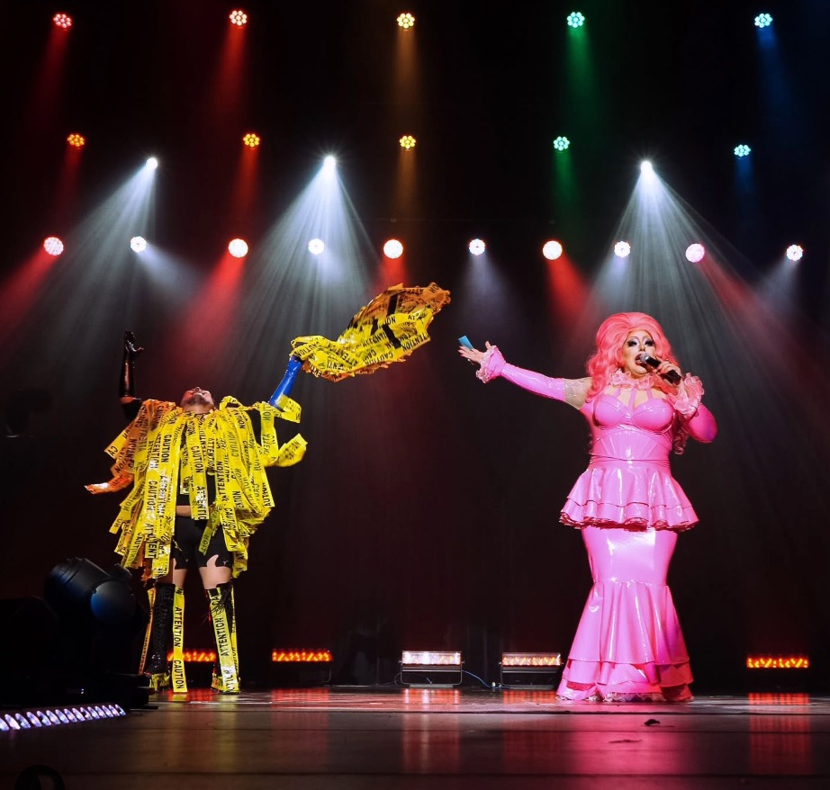 Drag queen Kitten Kaboodle in a pink gown on stage performing in North Bay Ontario. 