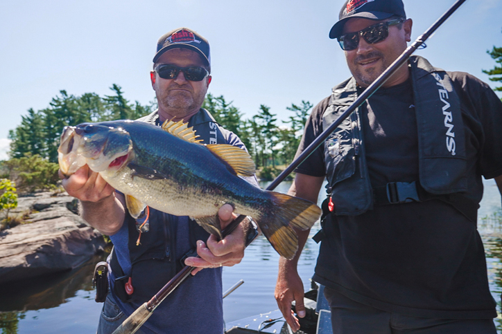 two anglers holding largemouth bass