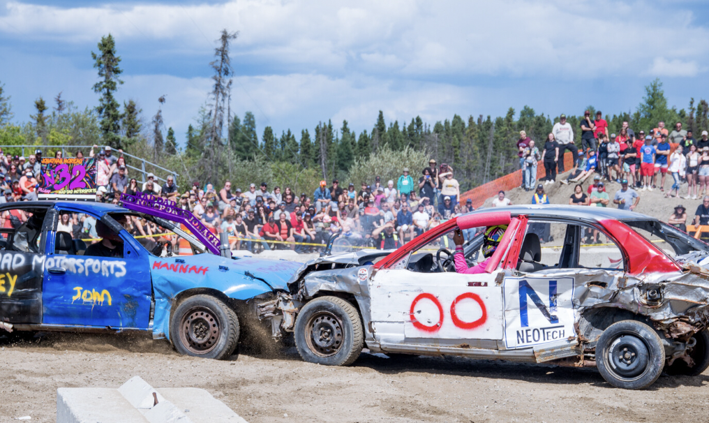 Derby cars smashing on a bluebird summer day in front of crowds