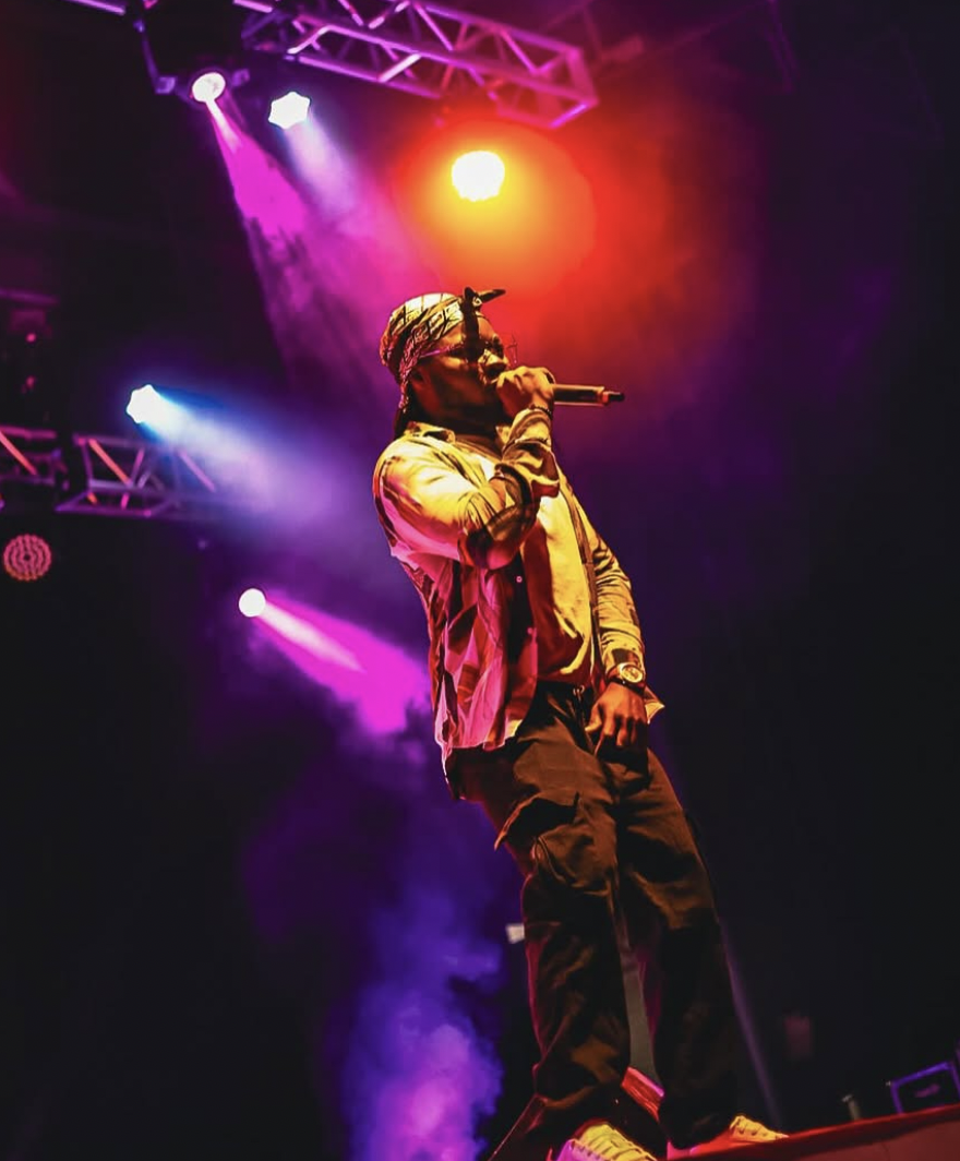 Singer on stage with colourful lights at Afrofest