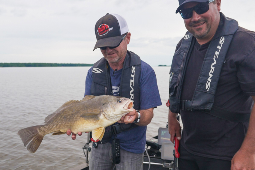 2 anglers holding bass