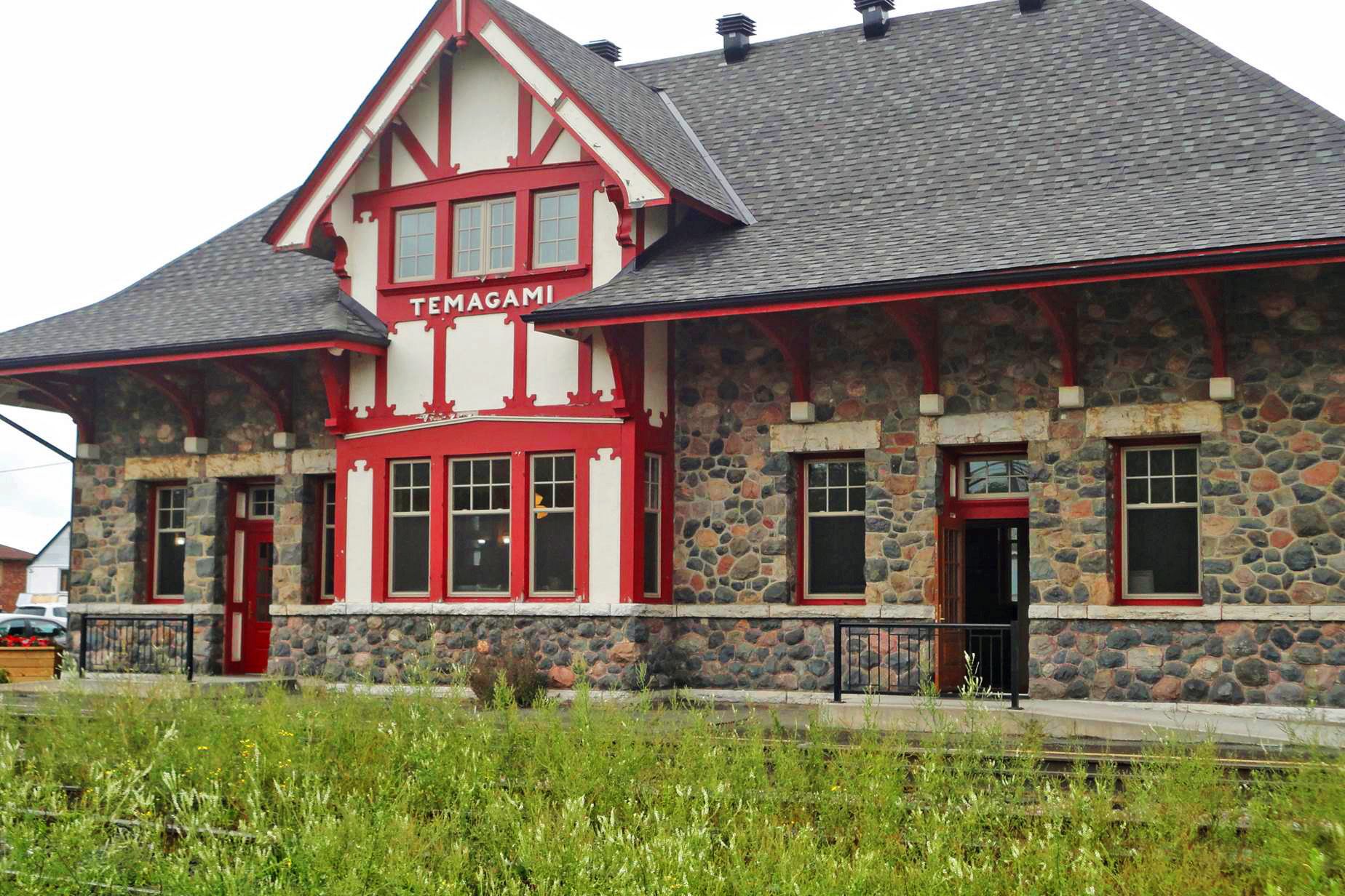 The Temagami Historic Train Station, an antique stone station house with red and white trim at the front.