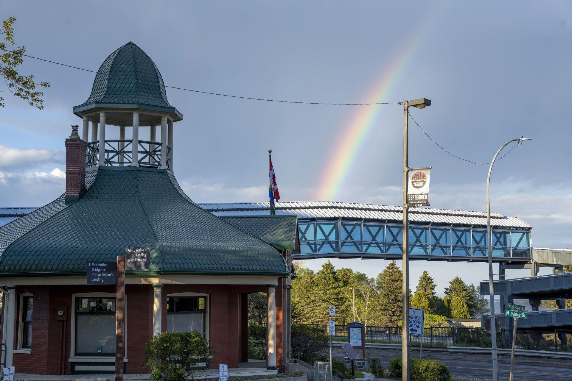 The Thunder Bay Pagoda, a green-roofed tower-shaped building that serves as a tourist information centre. The sky above it is showing a rainbow.