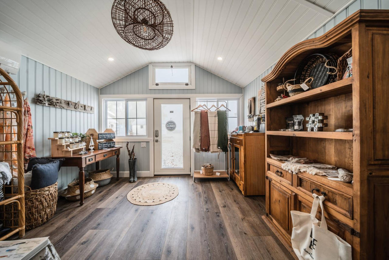 a clean, spacious cabin with white walls and shiny wooden floors and furniture, lit by bright windows.