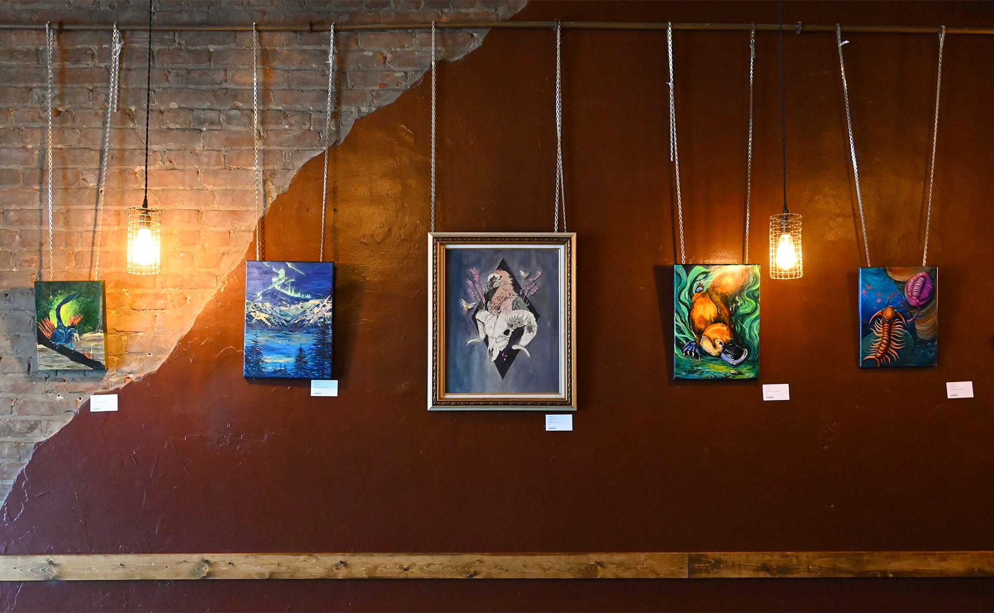 art displayed on a lit wall at Laughing Buddha.