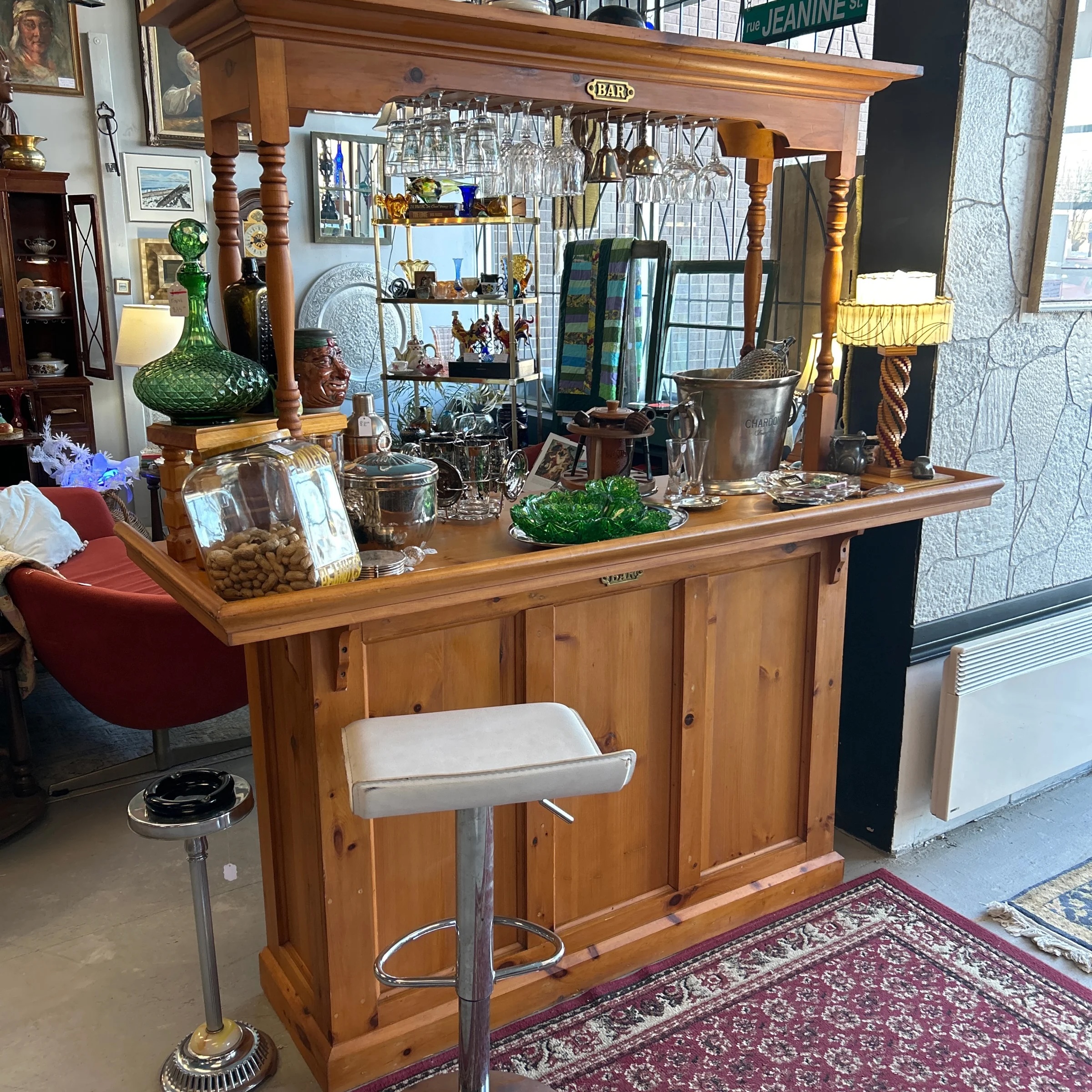 an early 1900s wooden bar covered in colourful vintage glassware