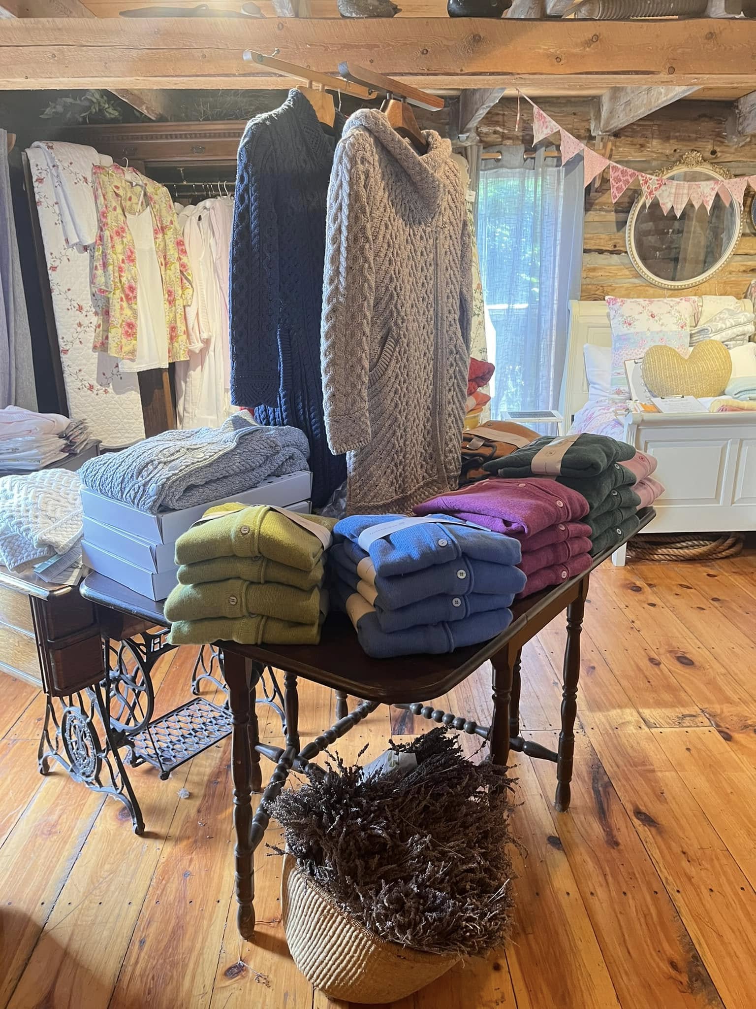 fine sweaters, scarves other textiles on display in a bright, clean, rustic wood building at Linens & Lavender.