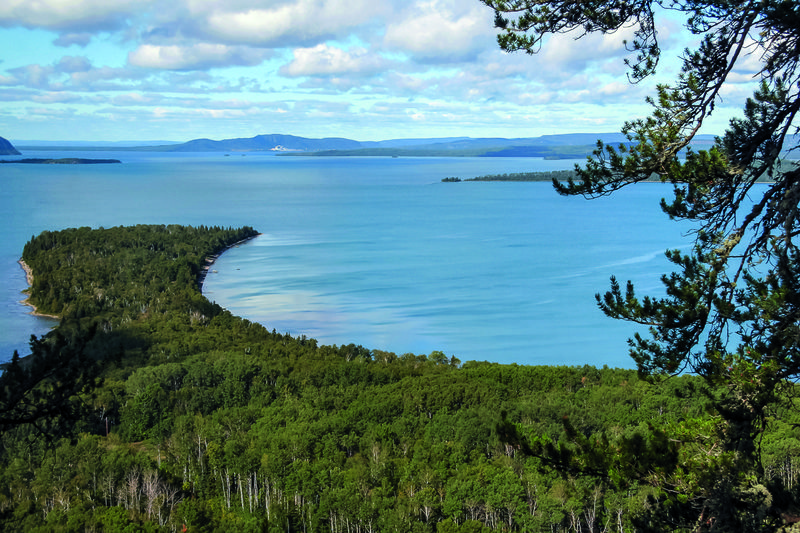 The broad blue expanse of Lake Superior surrounded by thick green boreal forest.