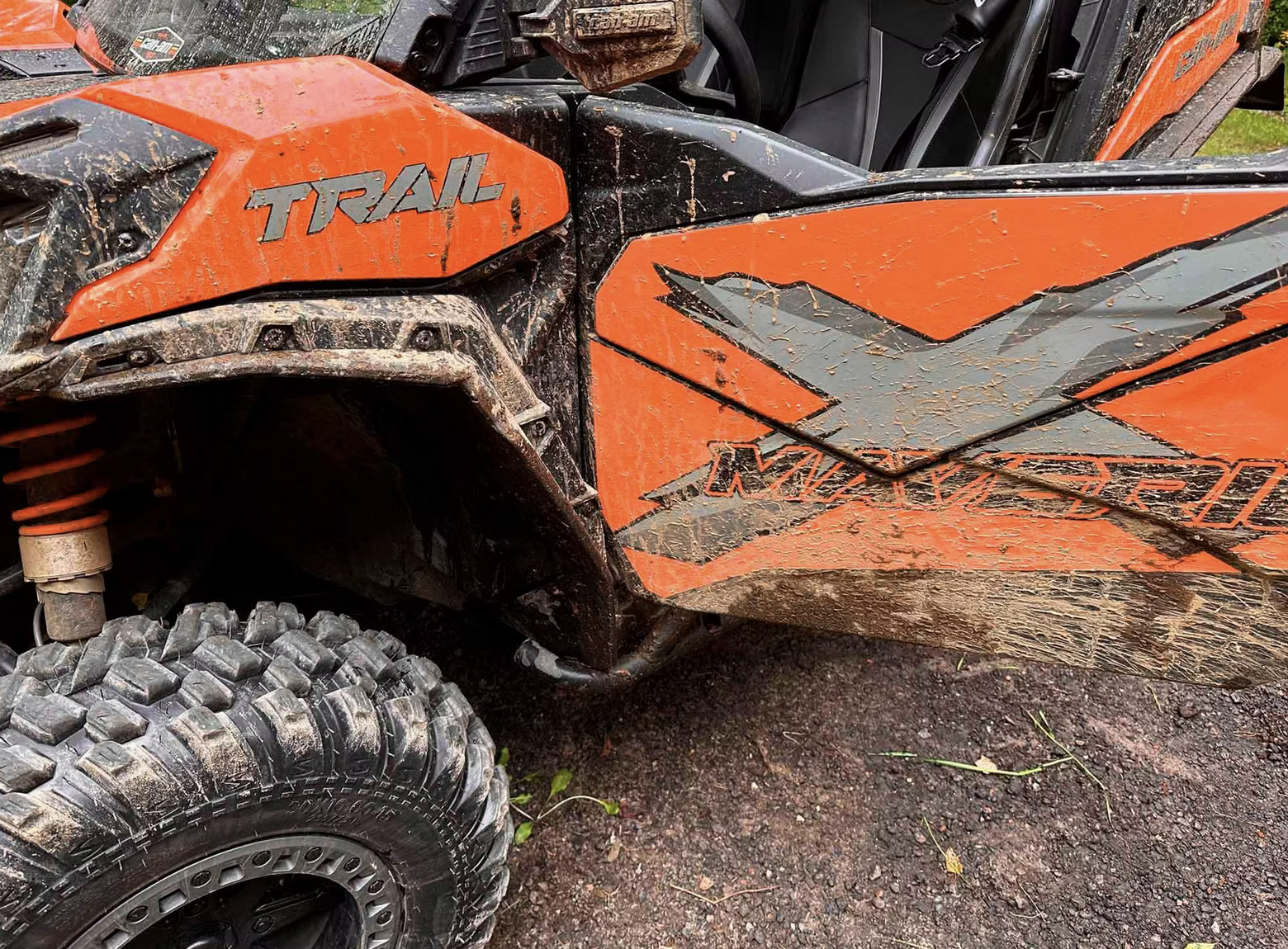 Mud sprayed up across the sides of a Can-Am Maverick after an offroad ride.