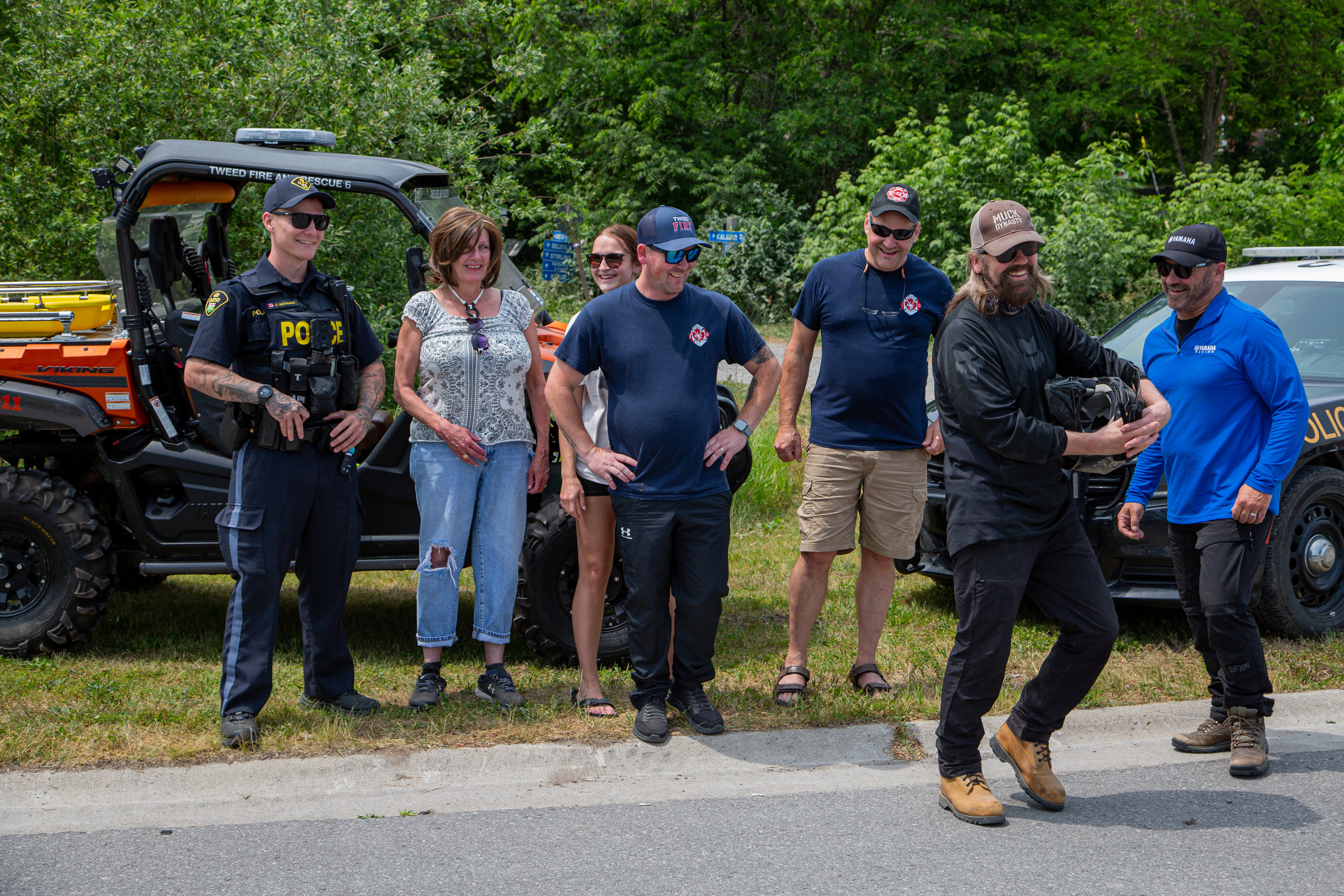 Larry Berrio and Jason McCoy laugh and joke with a group of first responders in Tweed, Ontario during the Rockin' the Trails event 2025.