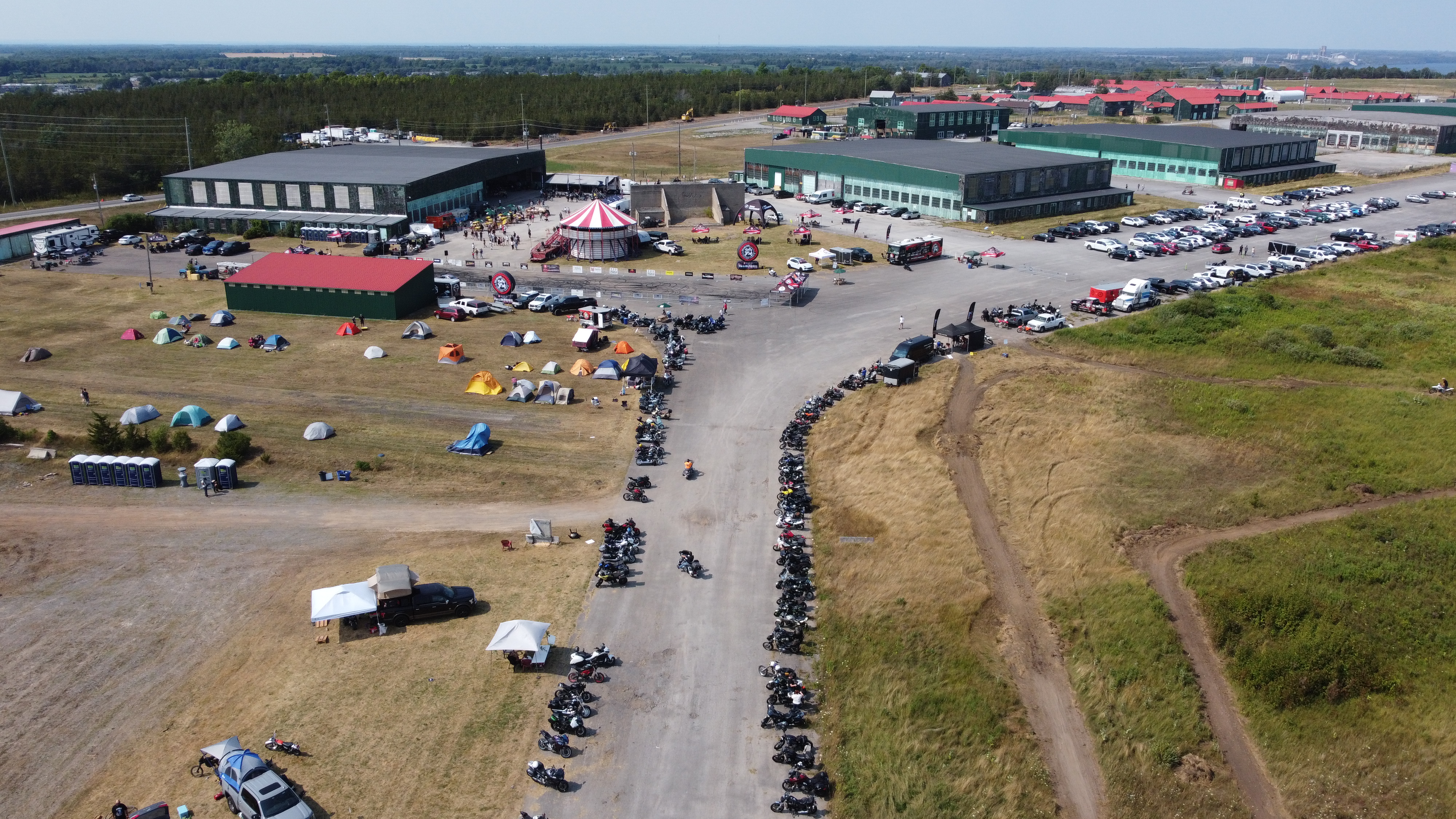 An aerial shot of Base31, filled with parked motorcycles along the roadways and eventgoers and tents on the grounds.