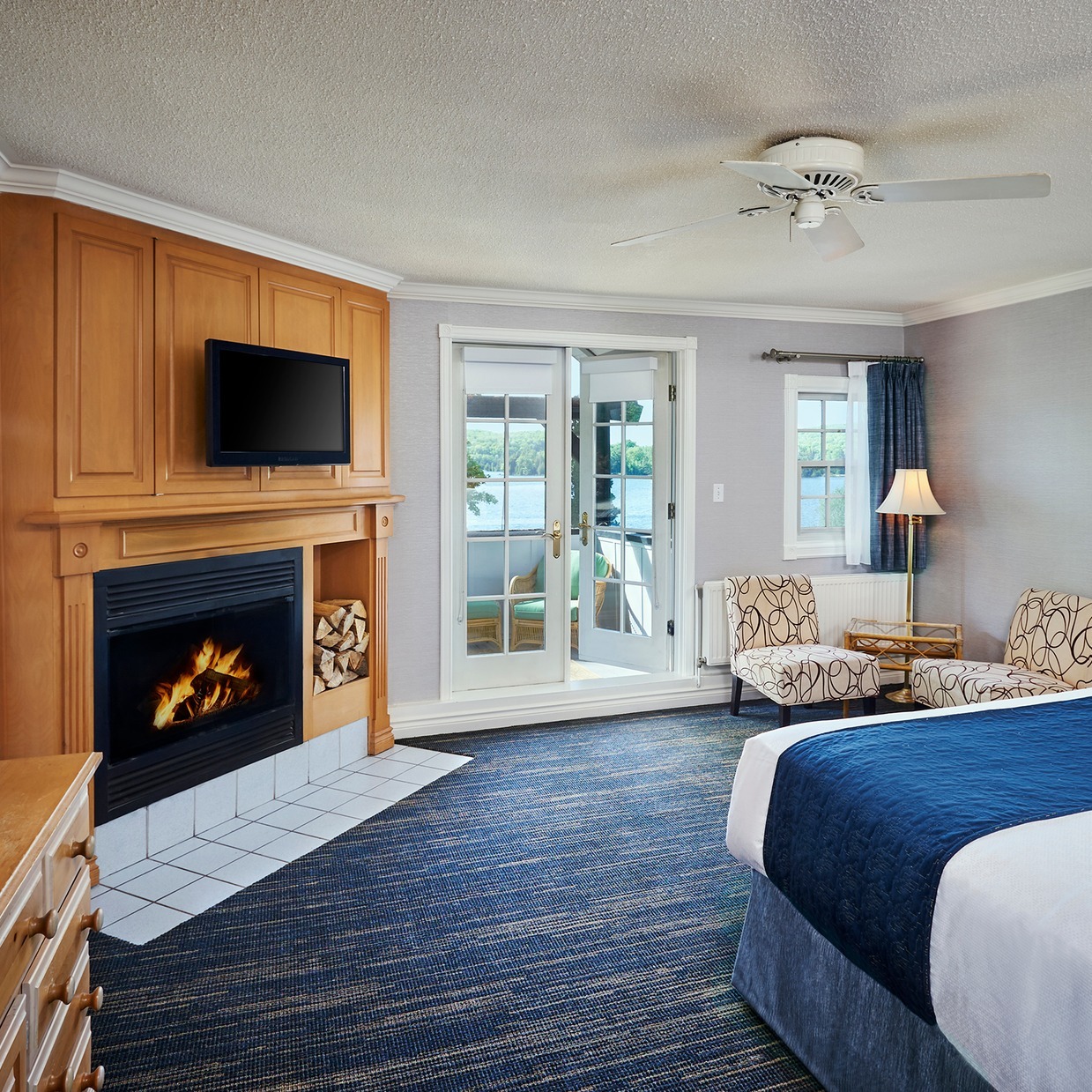 a lavish, pristine hotel room with fireplace and french doors walking out onto a patio.