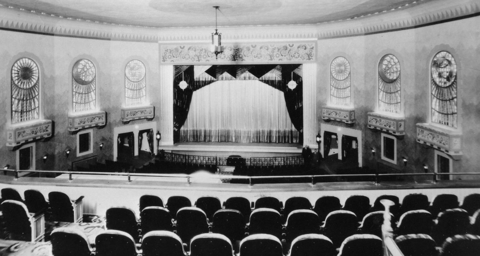 a black and white photograph of the ornate art deco Capitol Centre Theatre with its rows of seats, elaborate mouldings and chandeliers. 