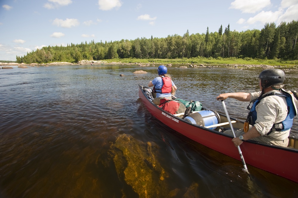 Two paddlers in canoe with helmets on