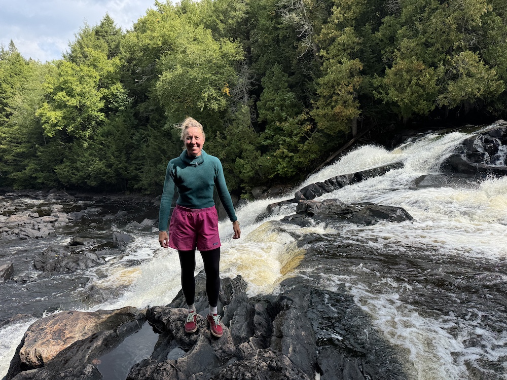 Woman standing in front of waterfall