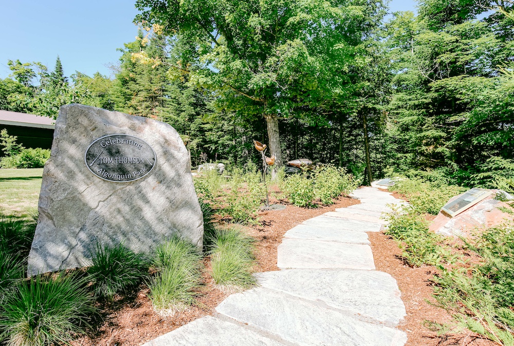 Paved pathway beside commemorative rock.