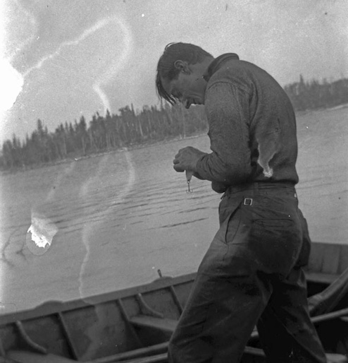 Tom Thomson standing in front of lake