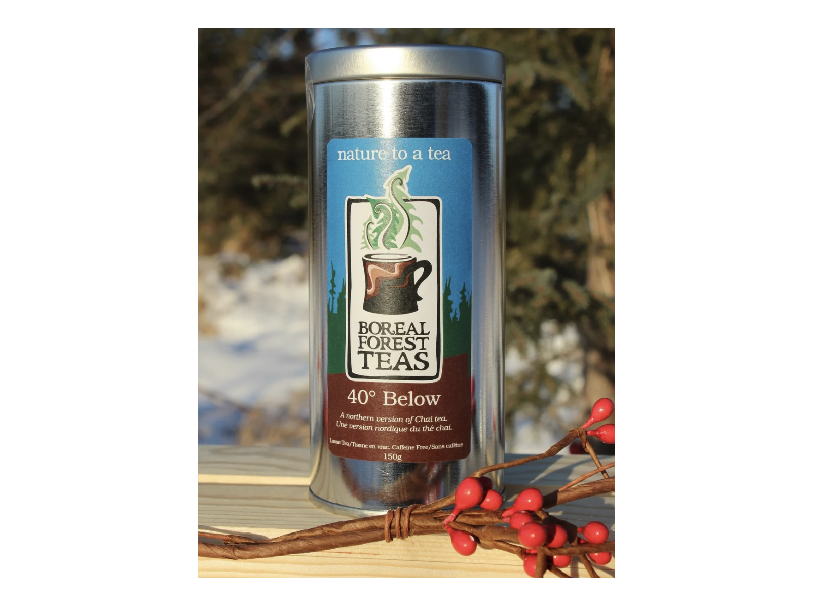 A tin of Boreal Forest 40 Below Tea on a wooden ledge outdoors, with a sprig of red winter berries next to it.