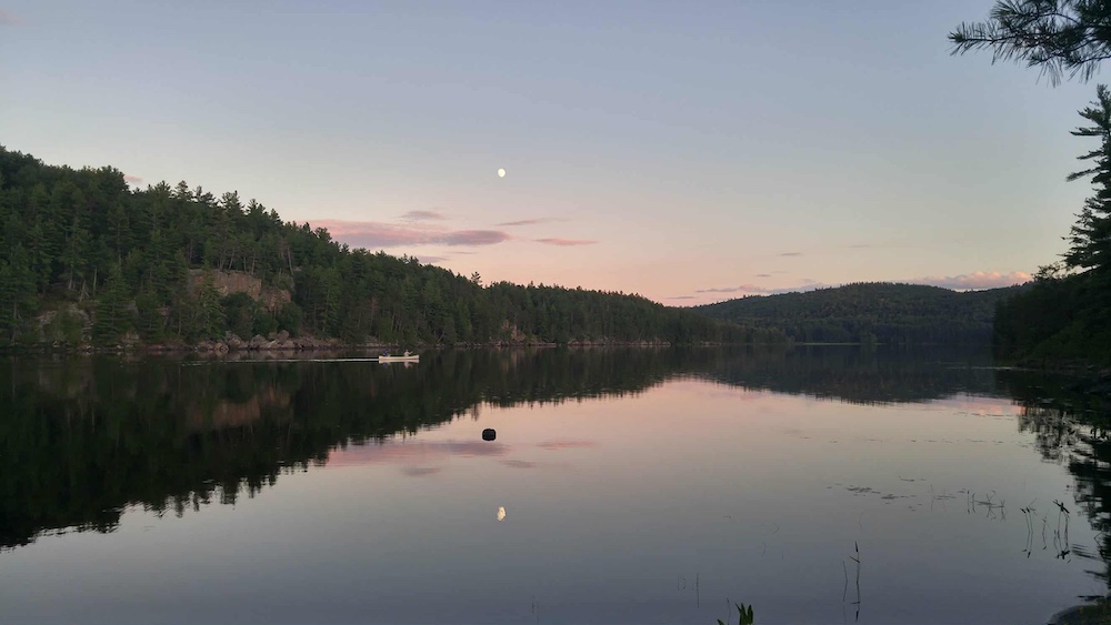 Canoe being paddled at sunset