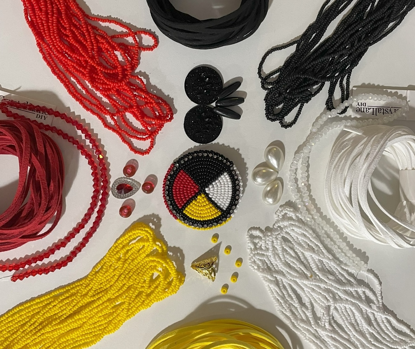 An array of strings of seed beads, leather and gems laid out to resemble a medicine wheel.