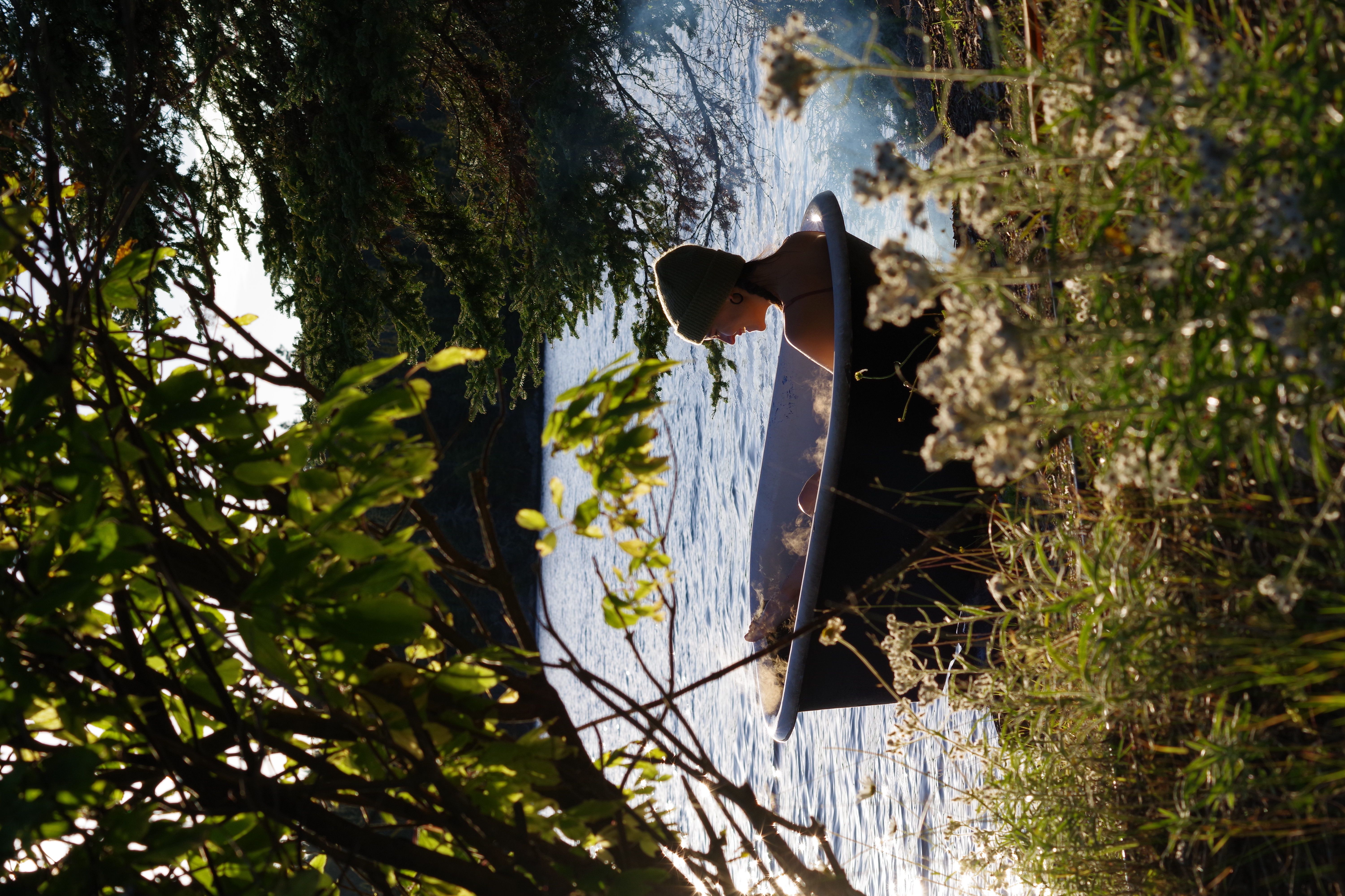 woman in bathtub on shore of lake