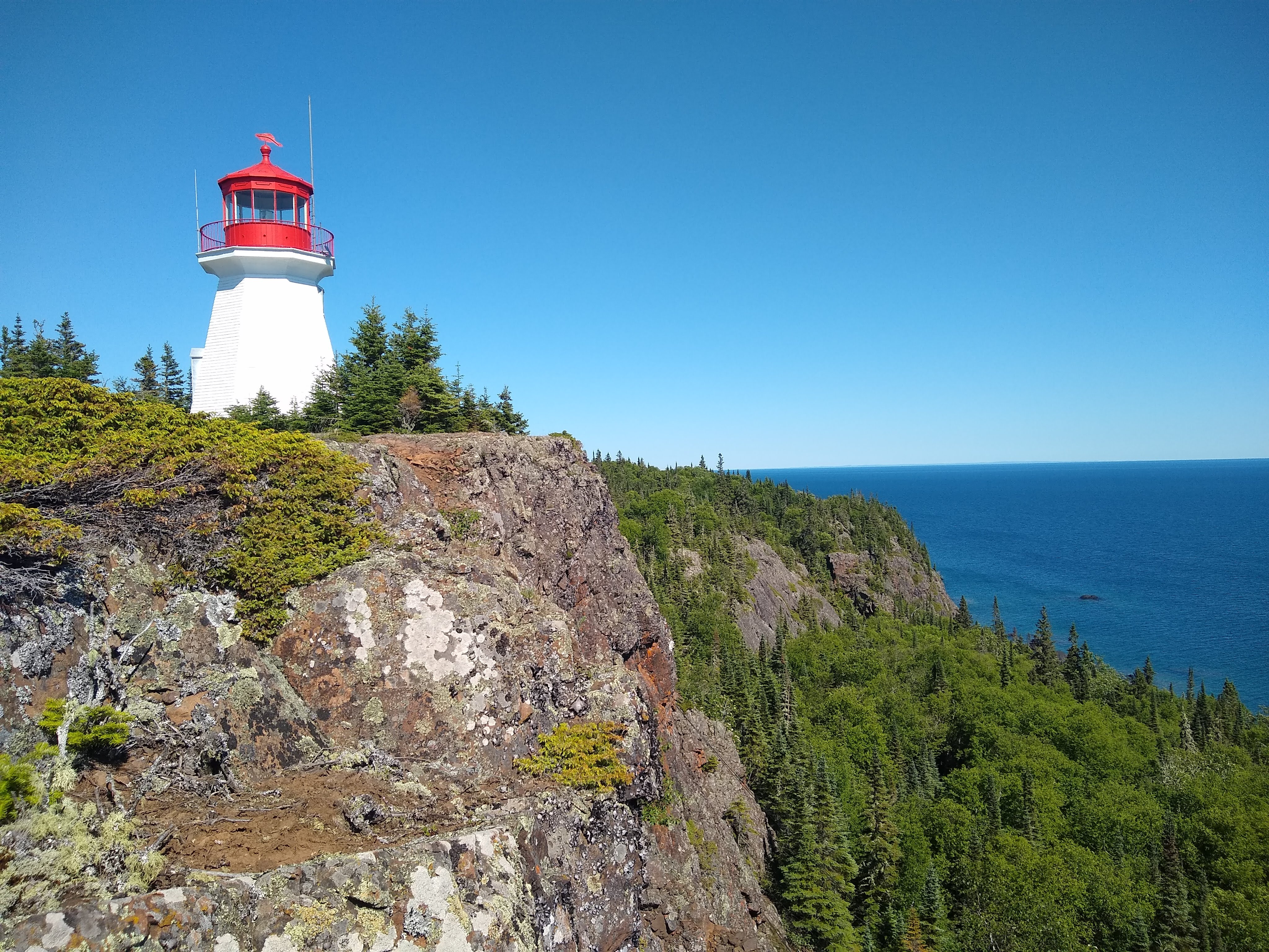 Red and white lighthouse up on cliffs