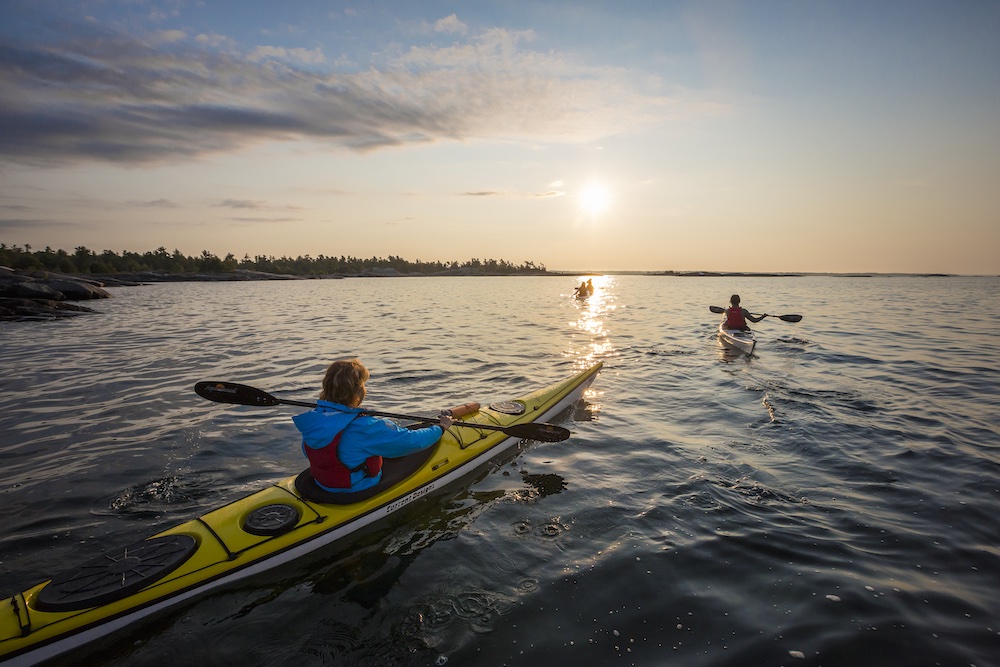 People in sea kayaks on wide-open lake