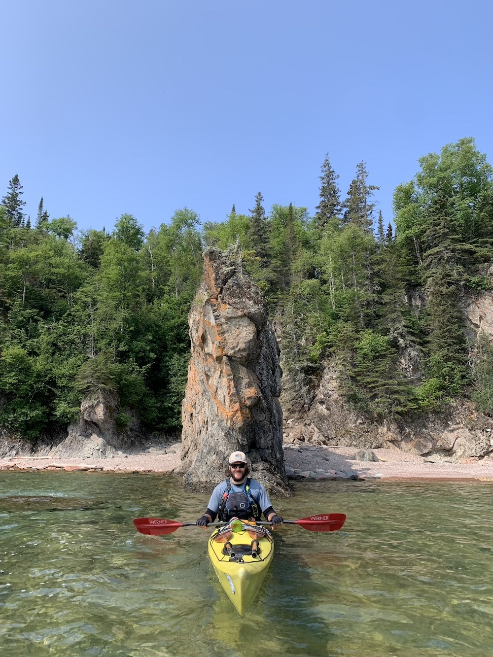Man in sea kayak with rock stack in background