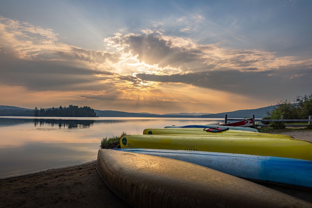 Rental canoes on shore next to a lake