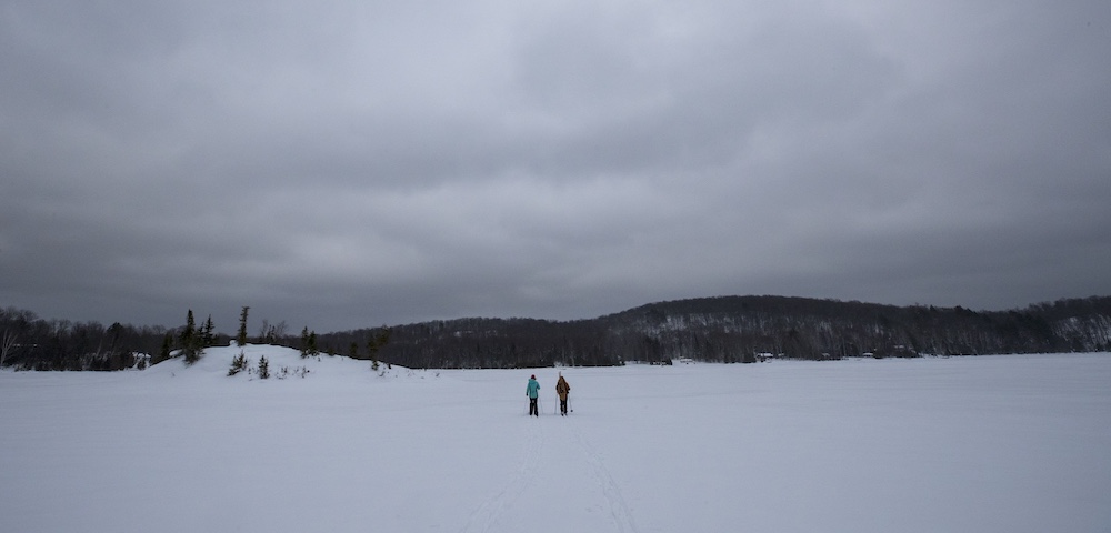 Two people skiing on snow-covered lake in the winter