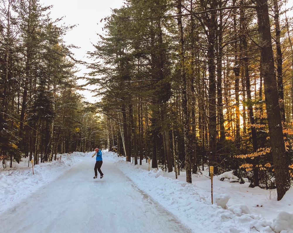 Woman skating on skating trail with trees on either side