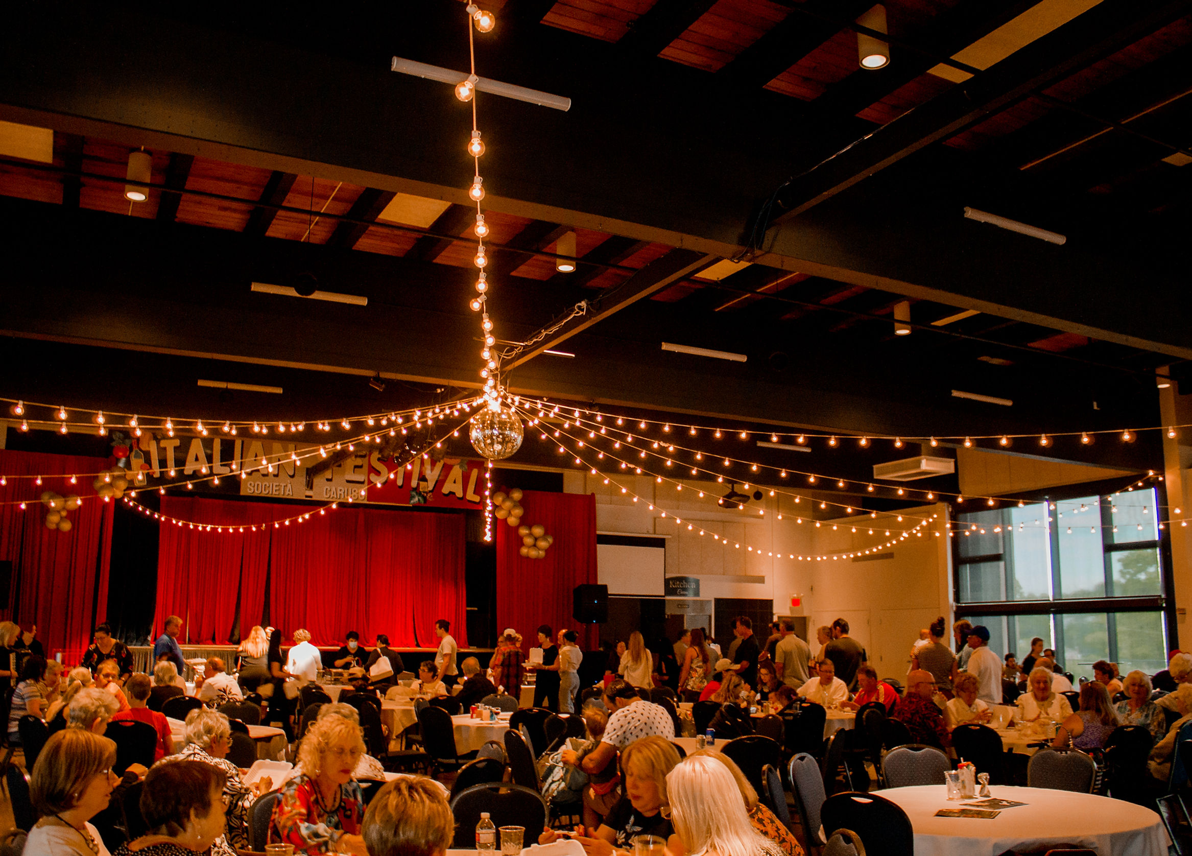 guests fill a large dining hall decorated with glowing strings of lights and a sparkling disco ball at the Caruso Club for the Italian Festival in Sudbury.