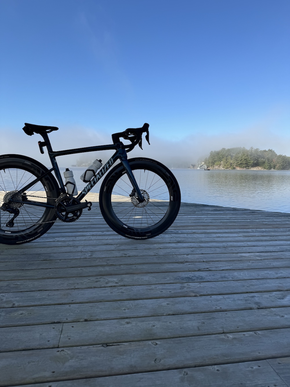 Road bike on dock next to lake with mist rising