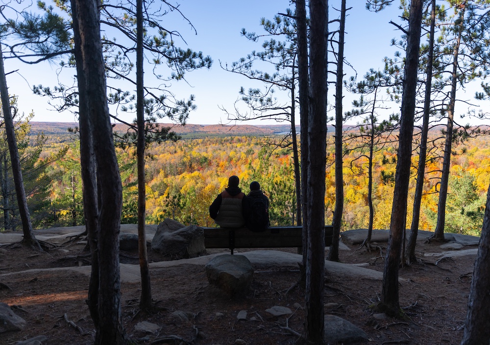 Two people sitting on bench at top of Lookout Trail