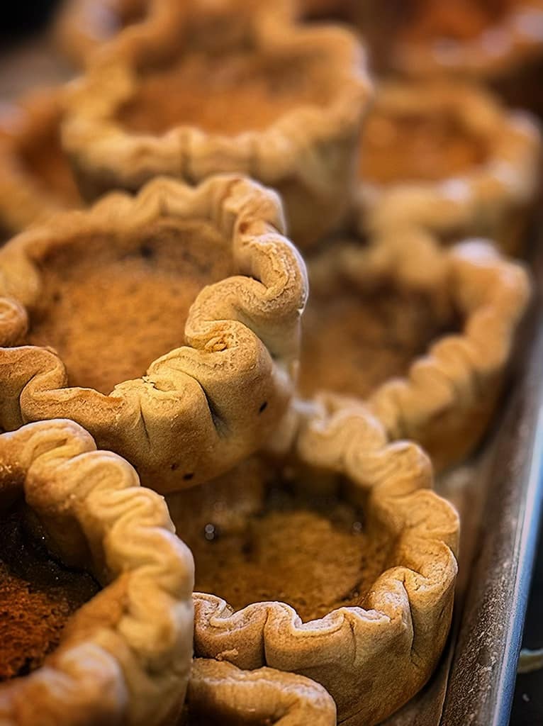 Golden butter tarts with delicately fluted edges stacked on a tray at Pinchman's in Sudbury.