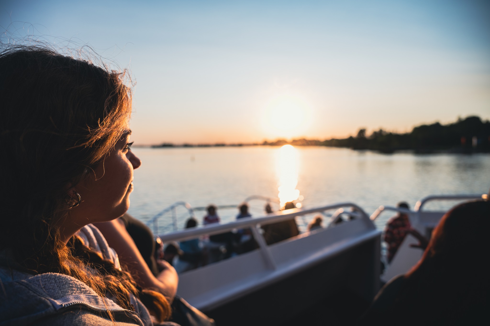 A girl aboard a passenger ship watches the sun set over the Sault Canal. 